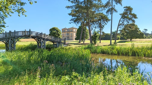 view of the house at croome on a sunny day from the river bank near the chinese bridge
